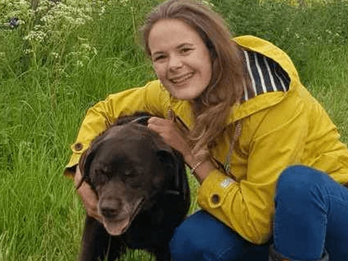 Katie cuddling a dog in the Woolmers paddock